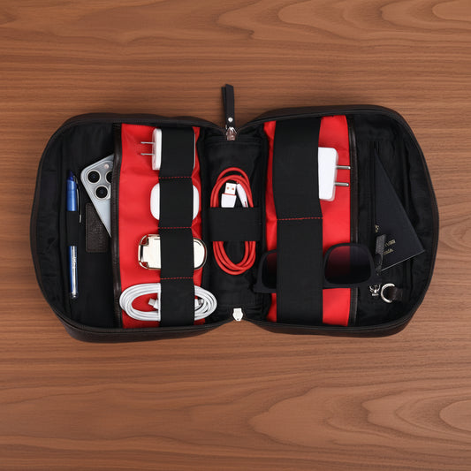 Black and red travel organizer with electronic accessories on a white background