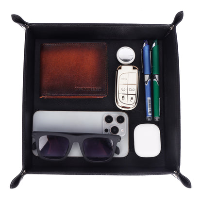 Black leather valet tray with various items including a wallet, phone, sunglasses, and pens.